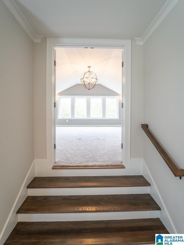 staircase with vaulted ceiling and ornamental molding