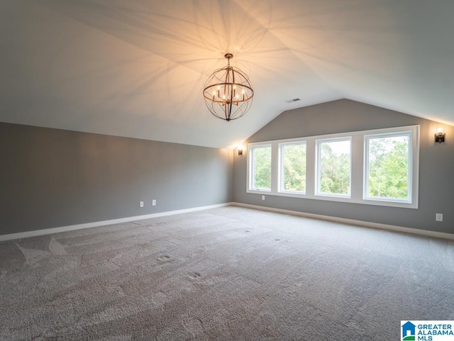 additional living space featuring a chandelier, carpet flooring, and vaulted ceiling