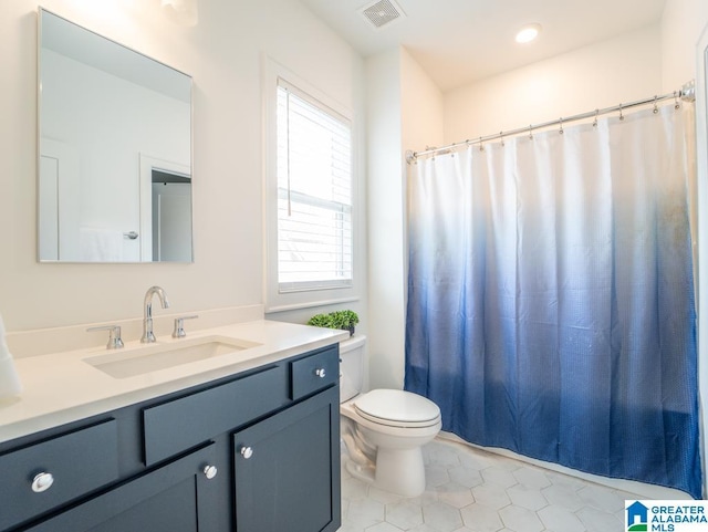 bathroom featuring curtained shower, tile patterned flooring, vanity, and toilet