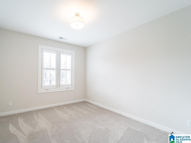 spare room featuring light colored carpet