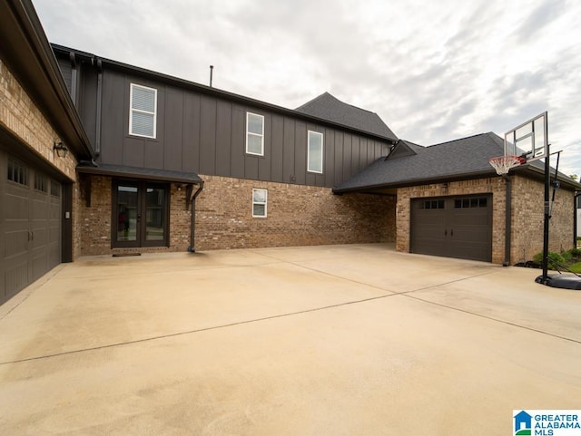 view of side of home with french doors and a garage