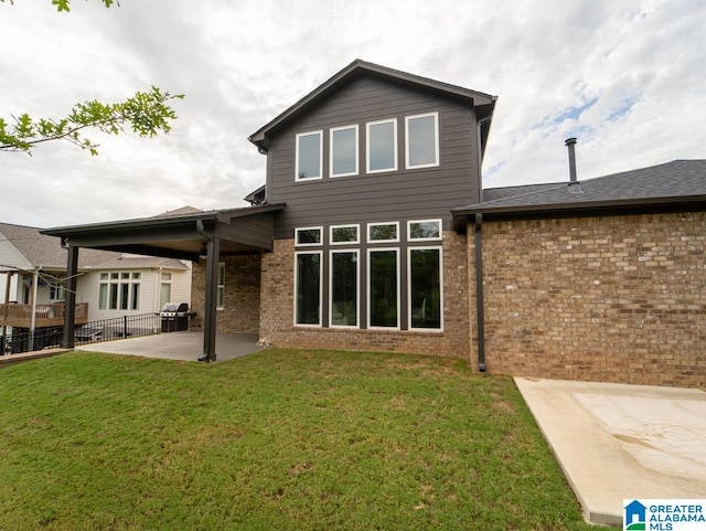 rear view of property featuring a yard and a patio