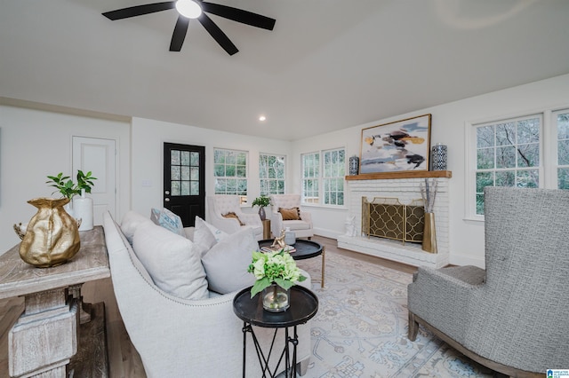 living room featuring ceiling fan, a fireplace, wood-type flooring, and plenty of natural light