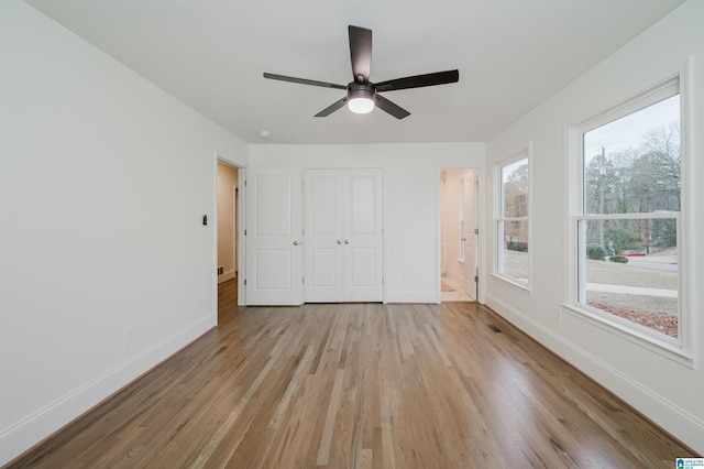 unfurnished bedroom with ceiling fan and light wood-type flooring