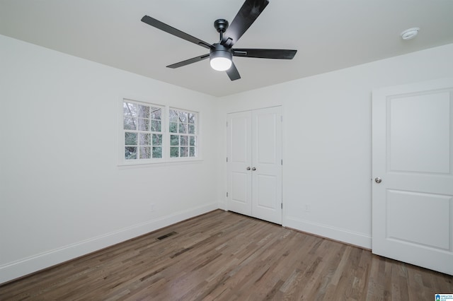 unfurnished bedroom with a closet, light hardwood / wood-style flooring, and ceiling fan