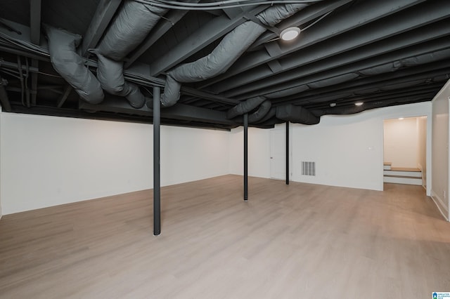 basement with light hardwood / wood-style flooring