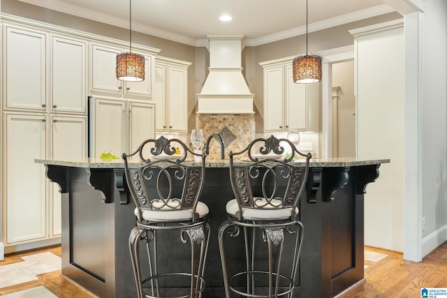 kitchen featuring light stone counters, hanging light fixtures, and a breakfast bar area