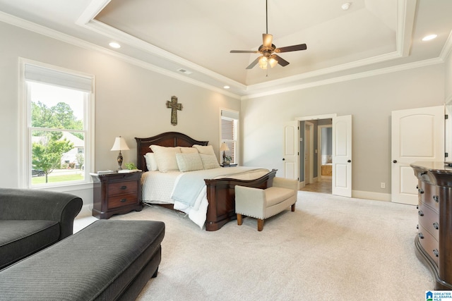 bedroom with light colored carpet, a raised ceiling, and ceiling fan