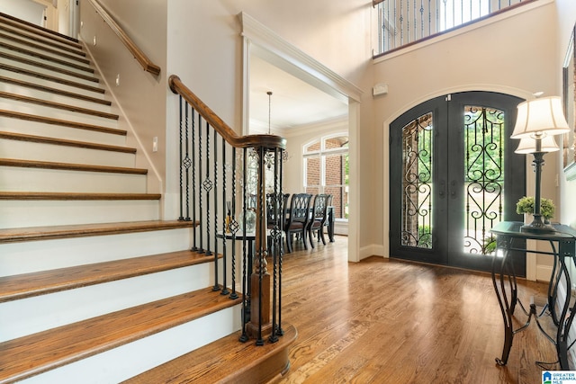 foyer featuring french doors, wood-type flooring, and ornamental molding