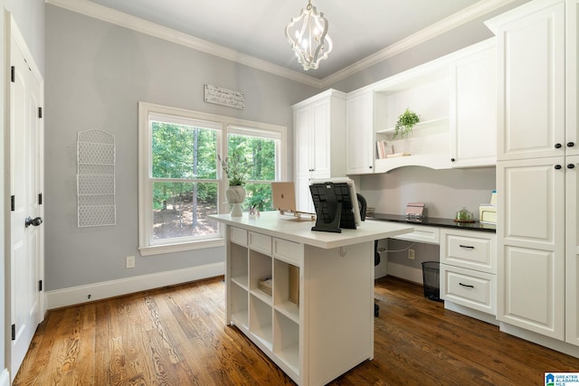 home office featuring crown molding, dark wood-type flooring, built in desk, and an inviting chandelier