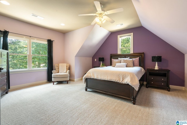 bedroom featuring multiple windows, light carpet, vaulted ceiling, and ceiling fan