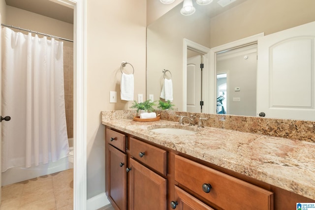 full bathroom with tile patterned flooring, shower / bath combo with shower curtain, vanity, and toilet