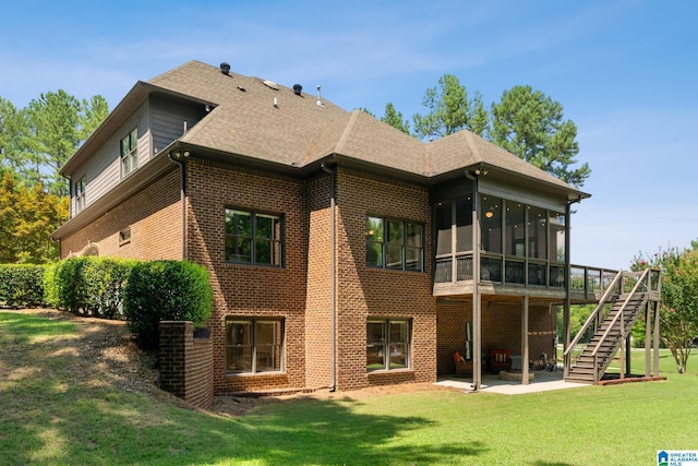 back of property featuring a lawn, a patio area, and a sunroom