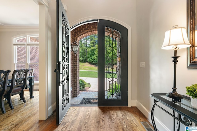 foyer entrance featuring hardwood / wood-style flooring and crown molding