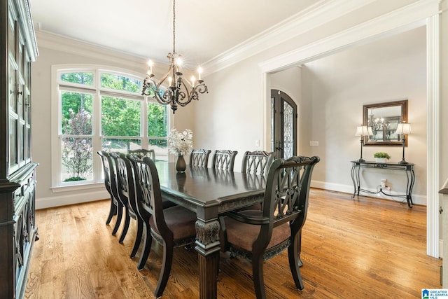 dining area featuring plenty of natural light, light hardwood / wood-style floors, ornamental molding, and a chandelier