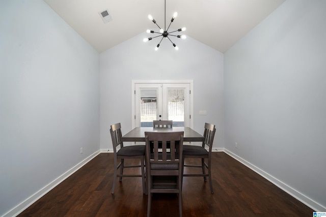 dining space with a chandelier, lofted ceiling, dark wood-type flooring, and french doors