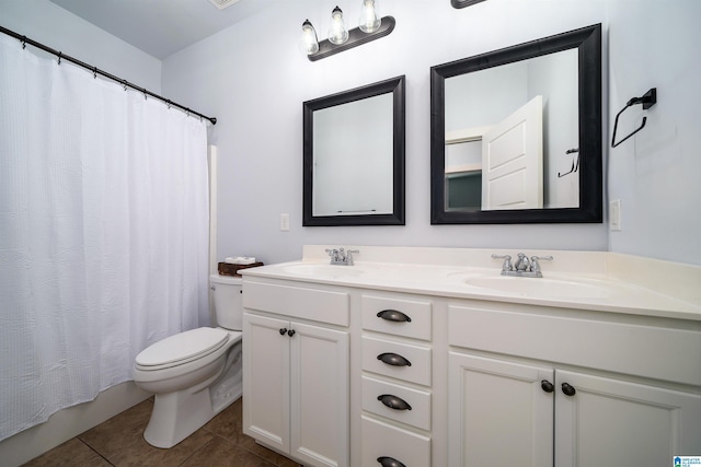 bathroom with toilet, vanity, and tile patterned floors