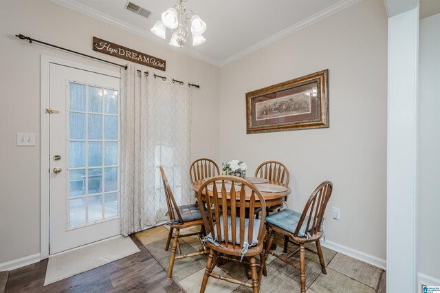 dining room featuring wood-type flooring, ornamental molding, and a notable chandelier