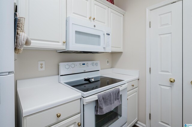 kitchen featuring white cabinets and white appliances