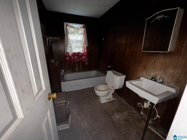 full bathroom featuring wooden walls, sink, shower / bath combination, and toilet