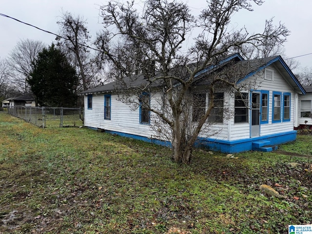 view of side of home with a yard