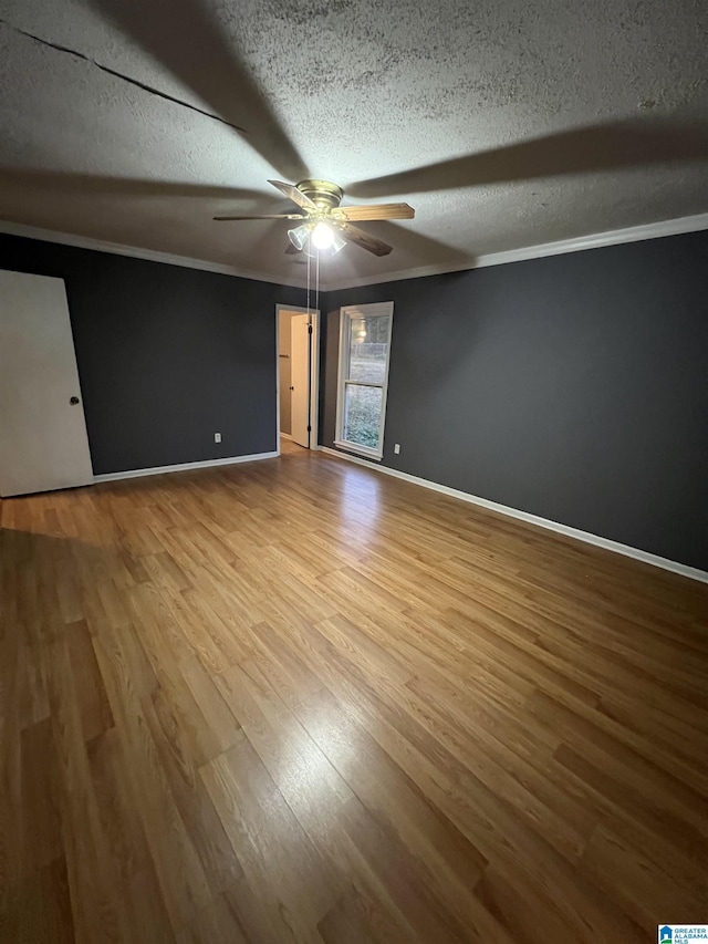 unfurnished bedroom with ceiling fan, light wood-type flooring, a textured ceiling, and ornamental molding