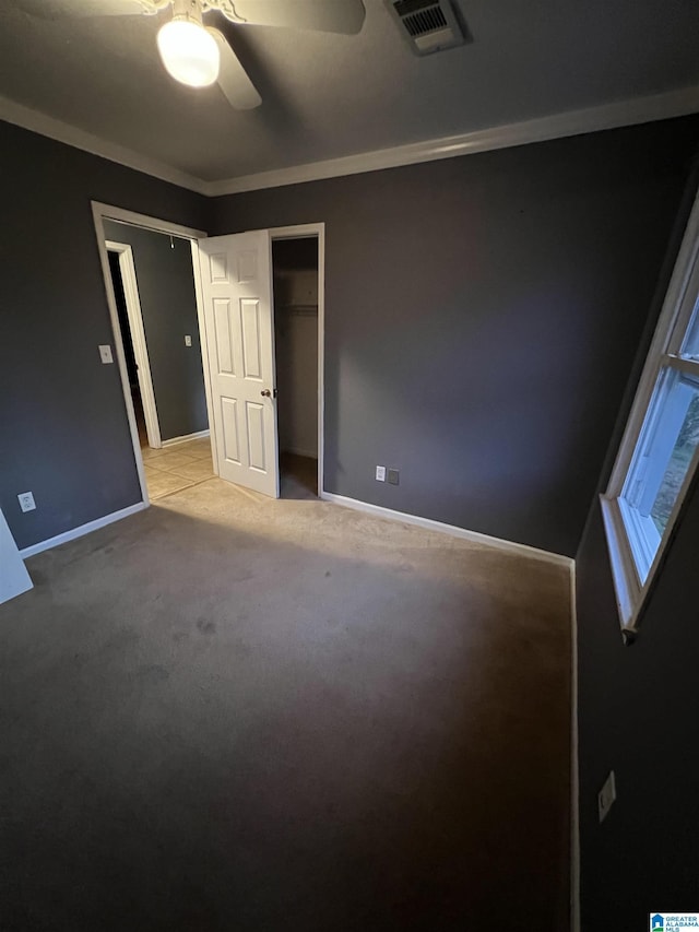 carpeted spare room with ceiling fan and ornamental molding