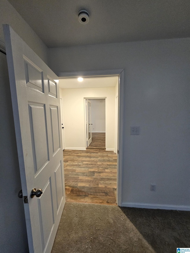 hallway featuring dark carpet