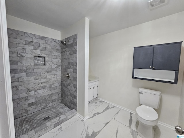 bathroom with toilet, vanity, and tiled shower