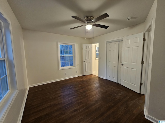 unfurnished bedroom with ceiling fan, dark hardwood / wood-style floors, and a closet