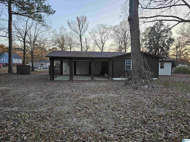 back house at dusk featuring a patio area