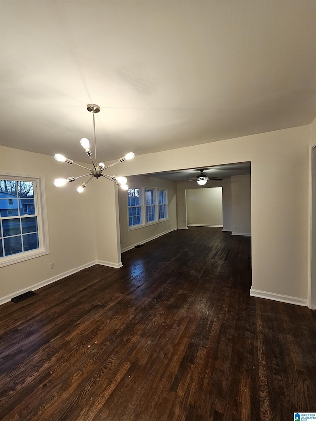 unfurnished living room with a chandelier and dark hardwood / wood-style flooring