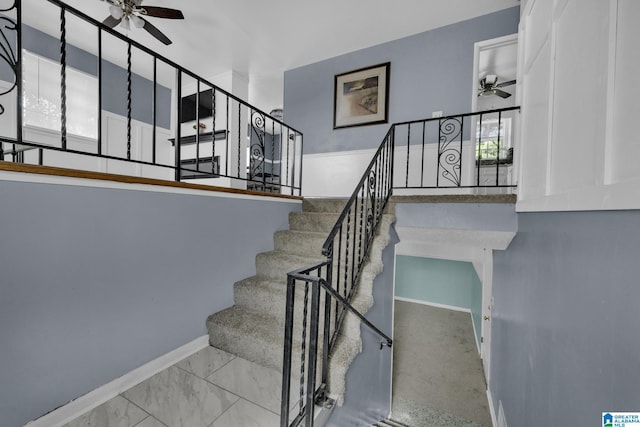 staircase featuring ceiling fan