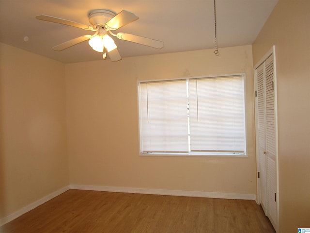 unfurnished bedroom with wood-type flooring, a closet, and ceiling fan