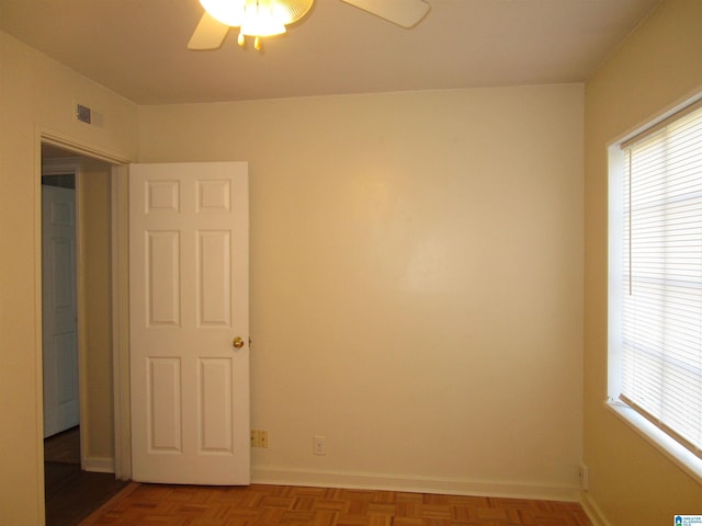 spare room featuring ceiling fan and parquet floors