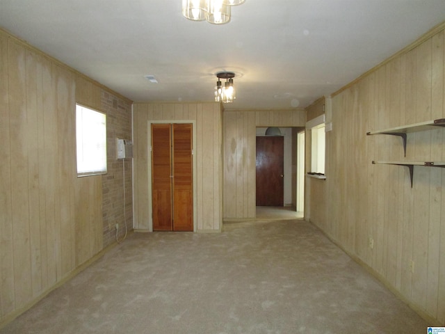 carpeted spare room with wood walls