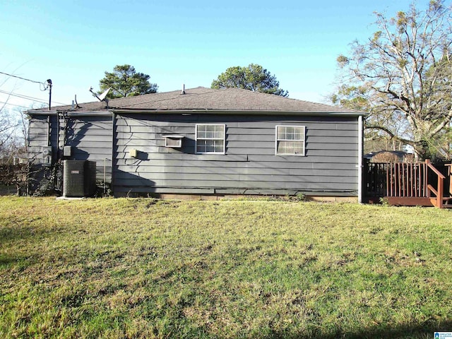 view of side of property featuring a yard and central AC