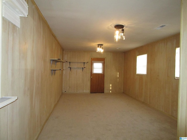 basement featuring light carpet and wood walls