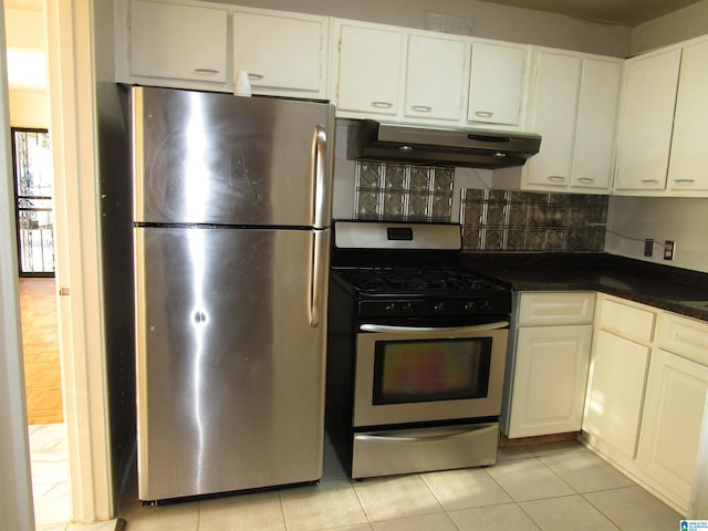 kitchen featuring tasteful backsplash, white cabinetry, light tile patterned floors, and appliances with stainless steel finishes