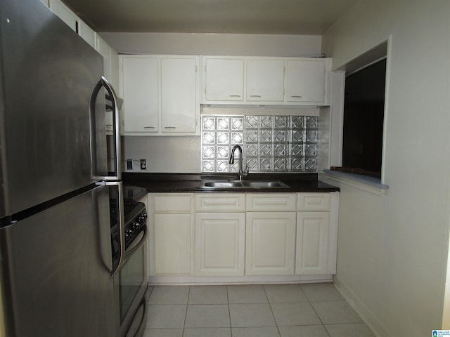 kitchen featuring stainless steel refrigerator, white cabinetry, sink, and stove