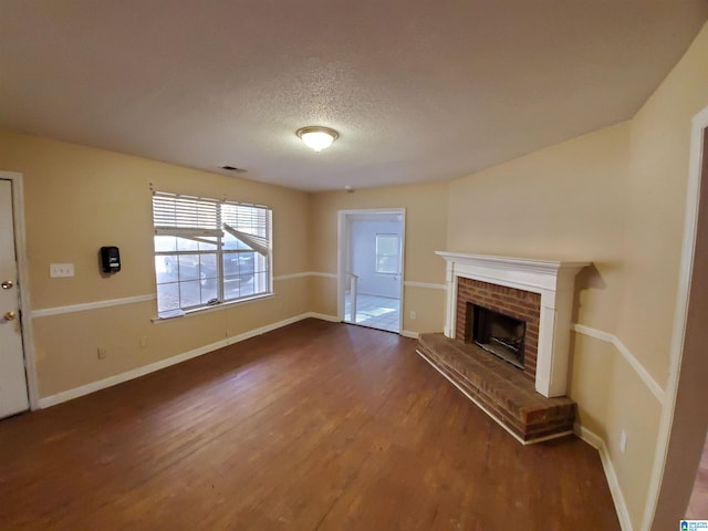 unfurnished living room featuring hardwood / wood-style flooring, a textured ceiling, and a fireplace