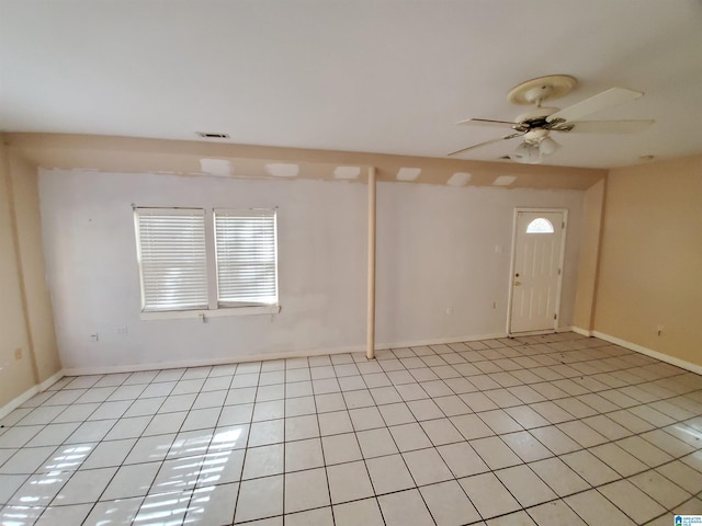 tiled spare room featuring ceiling fan