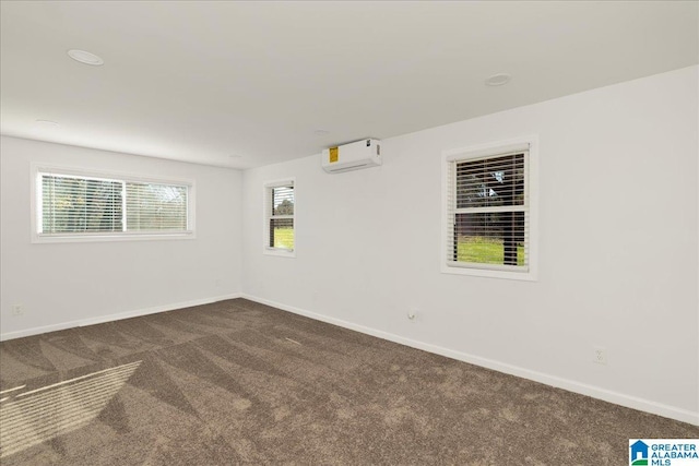 unfurnished room featuring dark carpet and an AC wall unit