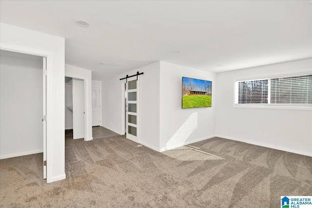 empty room with carpet and a barn door