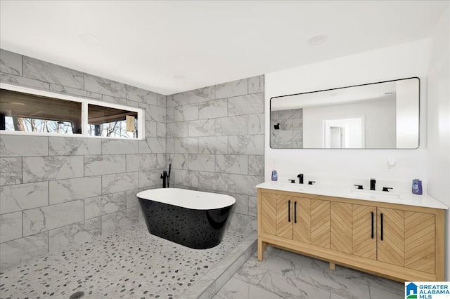 bathroom featuring a washtub, vanity, and tile walls