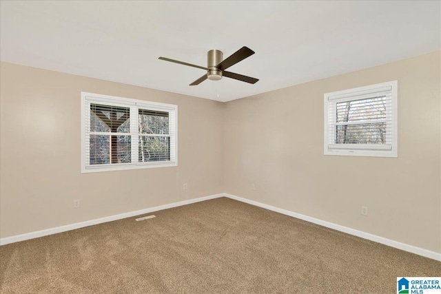 empty room featuring ceiling fan and carpet