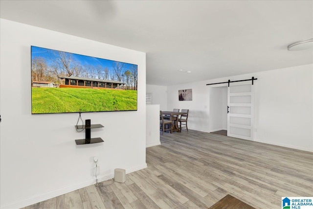 interior space with a barn door and light hardwood / wood-style flooring