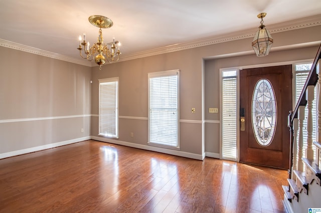 entryway featuring crown molding, hardwood / wood-style floors, and an inviting chandelier