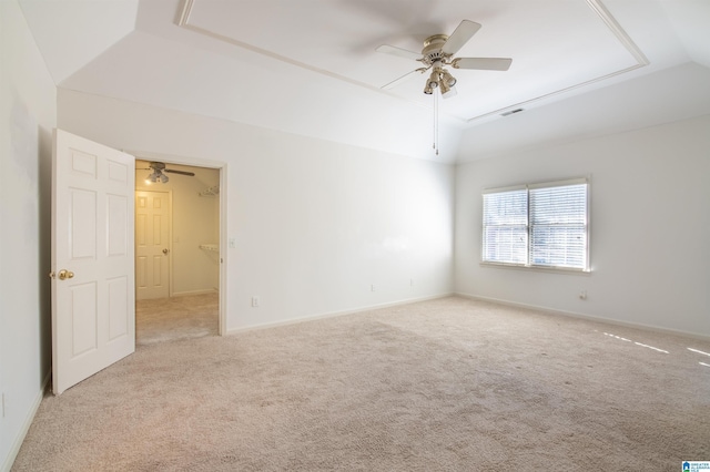 carpeted spare room with ceiling fan, a raised ceiling, and lofted ceiling