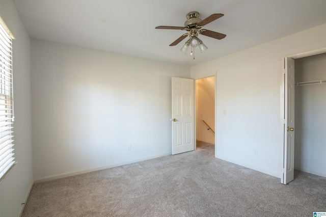 unfurnished bedroom featuring ceiling fan, a closet, and light carpet